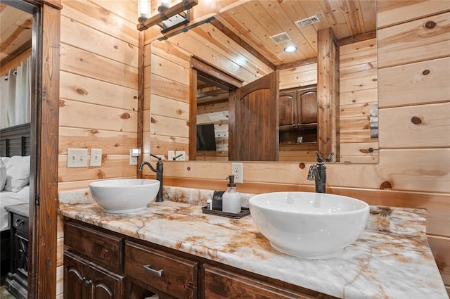 bathroom with wooden walls, vanity, and wood ceiling