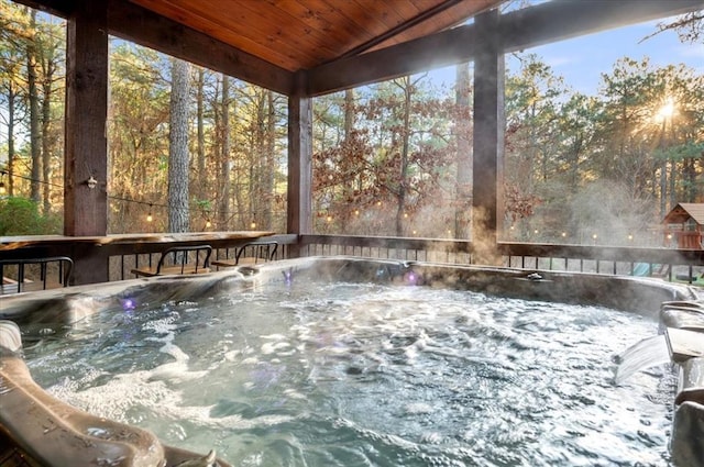 unfurnished sunroom featuring vaulted ceiling, wooden ceiling, and a hot tub