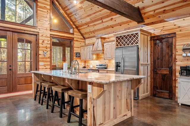 kitchen with finished concrete flooring, stainless steel appliances, and wooden walls