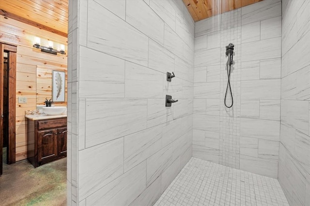 bathroom with tiled shower and vanity