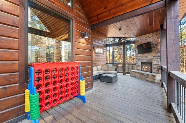 deck featuring an outdoor living space with a fireplace and a ceiling fan