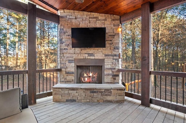 deck with an outdoor stone fireplace