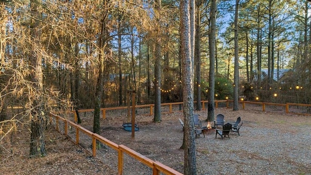 view of yard with an outdoor fire pit and fence