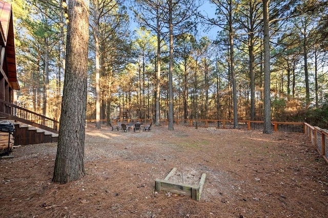 view of yard with fence and stairs