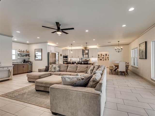 tiled living room featuring ceiling fan with notable chandelier, crown molding, and wine cooler