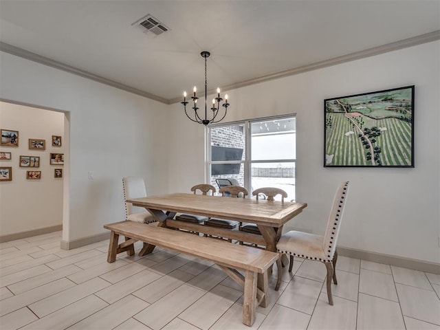 dining space featuring ornamental molding and a notable chandelier