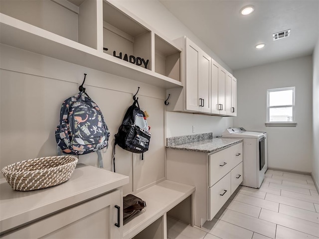 mudroom with washer and dryer and light tile patterned flooring