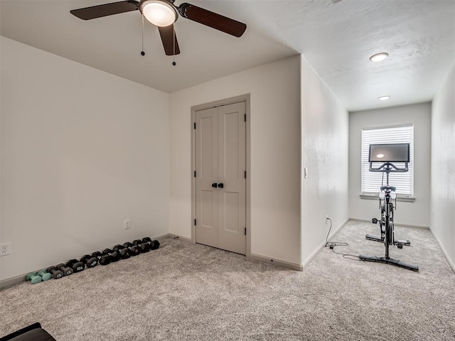 exercise area featuring ceiling fan and light colored carpet