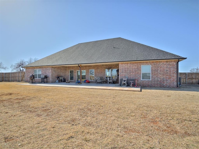 back of house featuring a patio area and a lawn