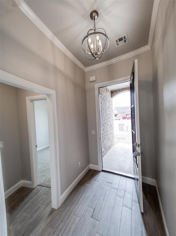 doorway featuring ornamental molding and an inviting chandelier