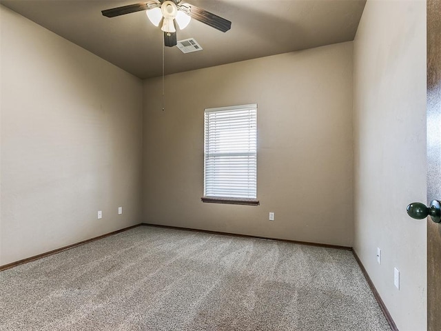 spare room with ceiling fan and carpet