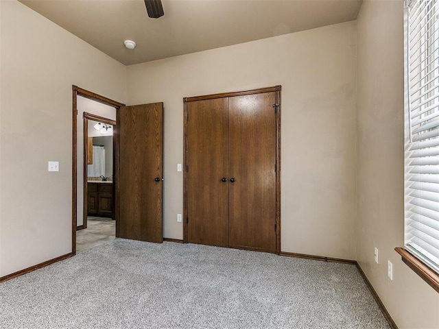 unfurnished bedroom featuring multiple windows, ceiling fan, a closet, and light colored carpet