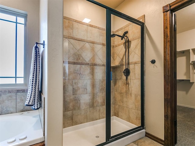 bathroom featuring plus walk in shower and a healthy amount of sunlight