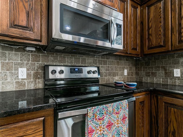 kitchen with dark brown cabinets, stainless steel appliances, and tasteful backsplash