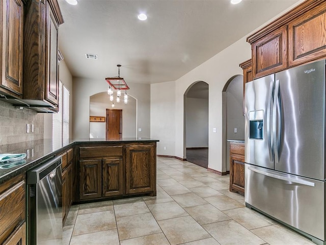 kitchen with kitchen peninsula, tasteful backsplash, stainless steel appliances, hanging light fixtures, and light tile patterned flooring