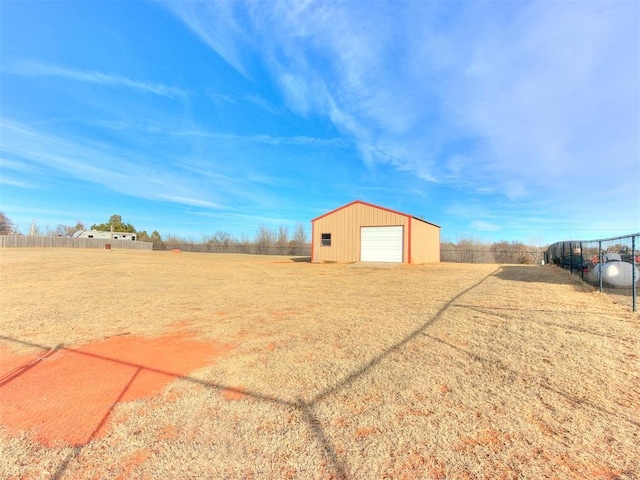 view of yard with a rural view, an outdoor structure, and a garage