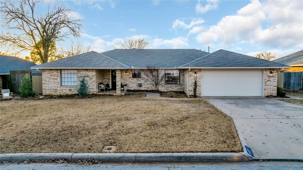 ranch-style house featuring a front yard and a garage