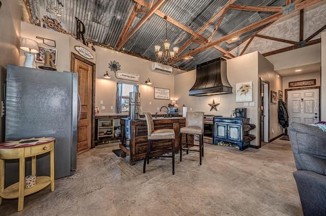 kitchen with a wall mounted air conditioner, appliances with stainless steel finishes, premium range hood, high vaulted ceiling, and a chandelier