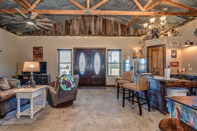 living room featuring beamed ceiling, high vaulted ceiling, and ceiling fan with notable chandelier
