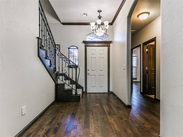 foyer featuring baseboards, stairway, ornamental molding, a textured wall, and dark wood-style flooring