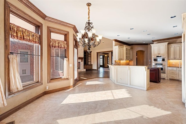 kitchen featuring crown molding, hanging light fixtures, stainless steel double oven, a chandelier, and cream cabinets