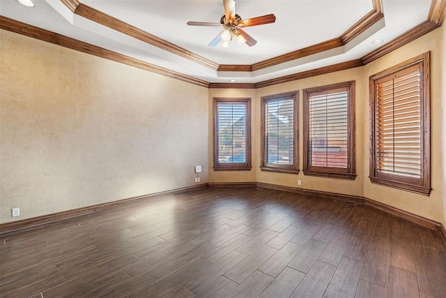 spare room featuring ceiling fan, a tray ceiling, and ornamental molding