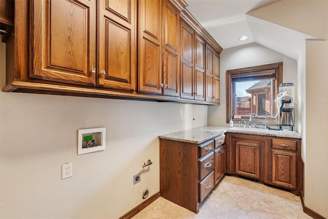 kitchen with light stone countertops, sink, and light tile patterned floors