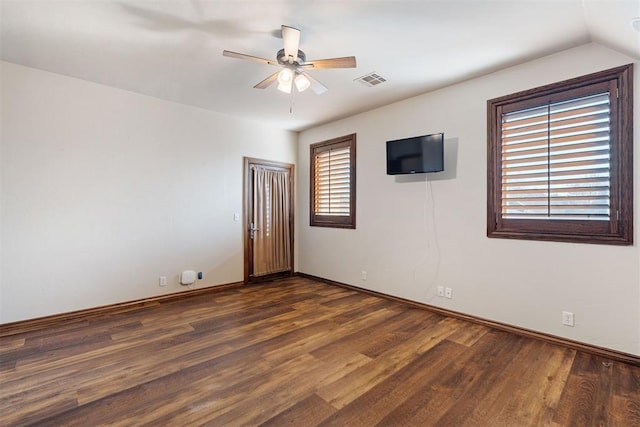 empty room with vaulted ceiling, ceiling fan, and dark hardwood / wood-style flooring