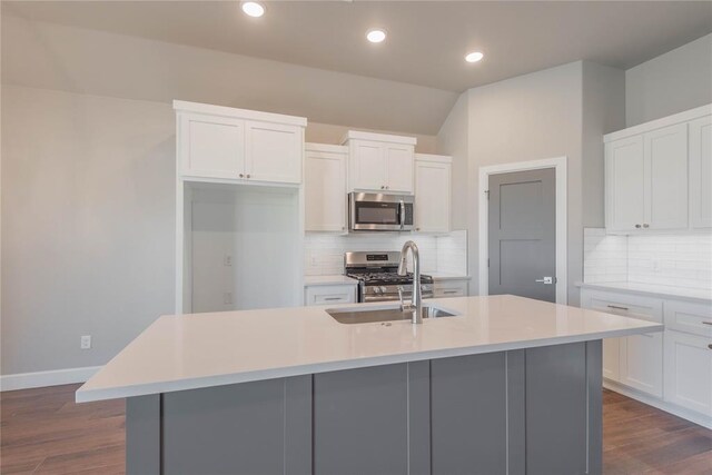 1300 Colonial Ave, Tuttle, OK 73089 - kitchen with sink, a center island with sink, appliances with stainless steel finishes, dark hardwood / wood-style floors, and white cabinets
