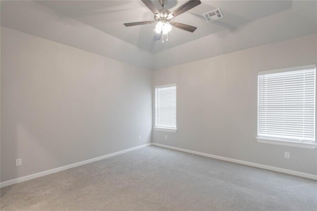 1300 Colonial Ave, Tuttle, OK 73089 - spare room featuring a raised ceiling, light colored carpet, and ceiling fan