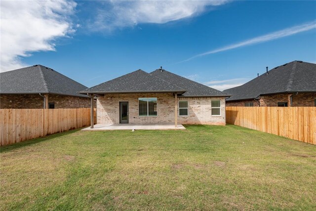 1300 Colonial Ave, Tuttle, OK 73089 - rear view of house featuring a lawn and a patio area