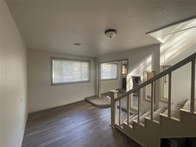 foyer entrance featuring dark wood-type flooring and a textured ceiling