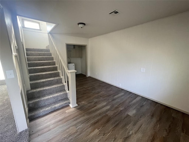 stairs with hardwood / wood-style flooring and washer / clothes dryer