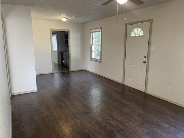 foyer entrance with a textured ceiling, dark hardwood / wood-style flooring, and ceiling fan