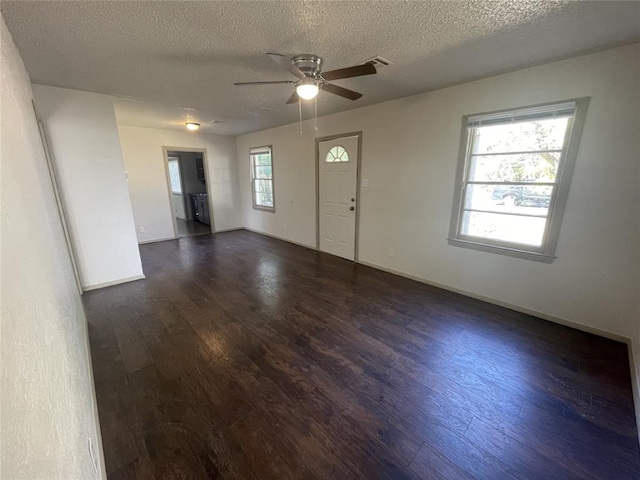 interior space featuring dark hardwood / wood-style floors, ceiling fan, and a textured ceiling