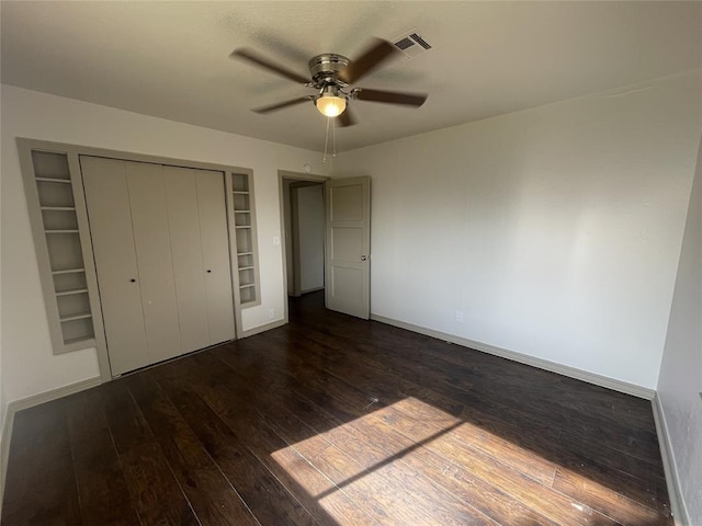 unfurnished bedroom featuring a closet, dark hardwood / wood-style floors, and ceiling fan