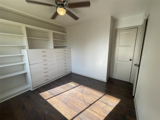 unfurnished bedroom with ceiling fan and dark wood-type flooring