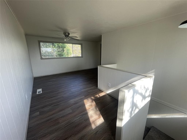 empty room featuring ceiling fan and dark wood-type flooring