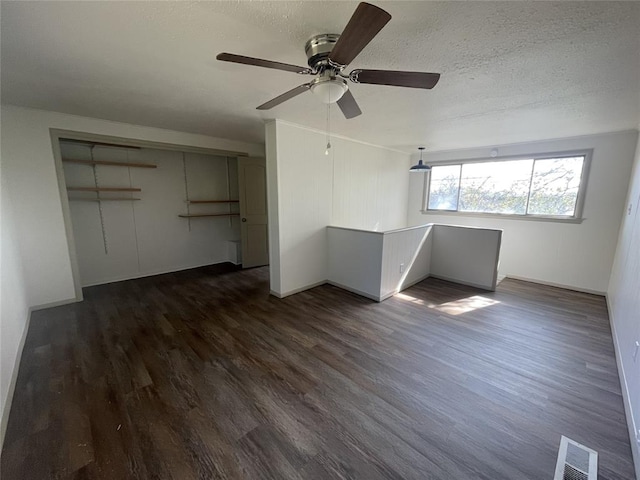 interior space featuring ceiling fan, dark hardwood / wood-style floors, a textured ceiling, and a closet