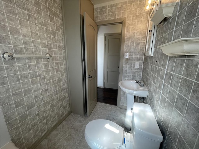 bathroom featuring tile patterned flooring, toilet, tile walls, and crown molding