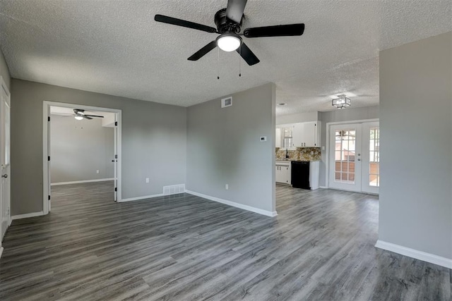 unfurnished living room with ceiling fan, french doors, a textured ceiling, and light wood-type flooring