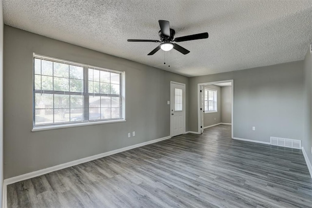 unfurnished room with hardwood / wood-style floors, a textured ceiling, and ceiling fan