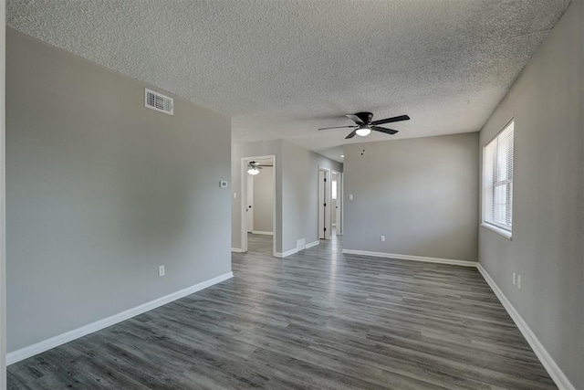 empty room with ceiling fan, dark hardwood / wood-style flooring, and a textured ceiling