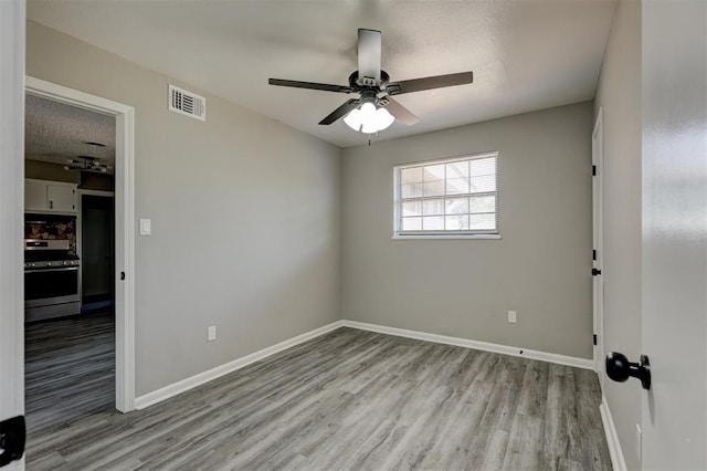 empty room featuring ceiling fan, light hardwood / wood-style floors, and a textured ceiling