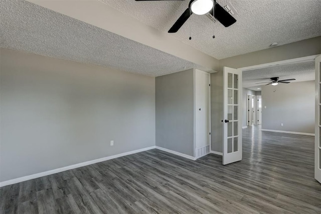 spare room with french doors, dark hardwood / wood-style floors, and a textured ceiling