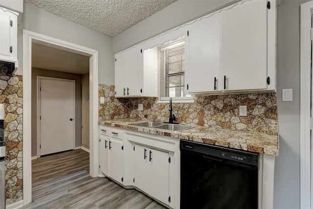 kitchen featuring white cabinetry, sink, black dishwasher, tasteful backsplash, and a textured ceiling