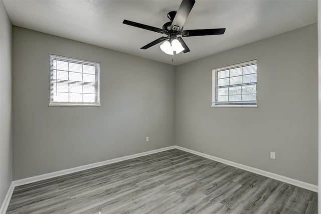 empty room featuring ceiling fan, plenty of natural light, and light hardwood / wood-style flooring