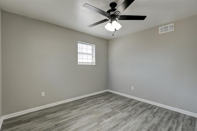 empty room with ceiling fan and light hardwood / wood-style flooring