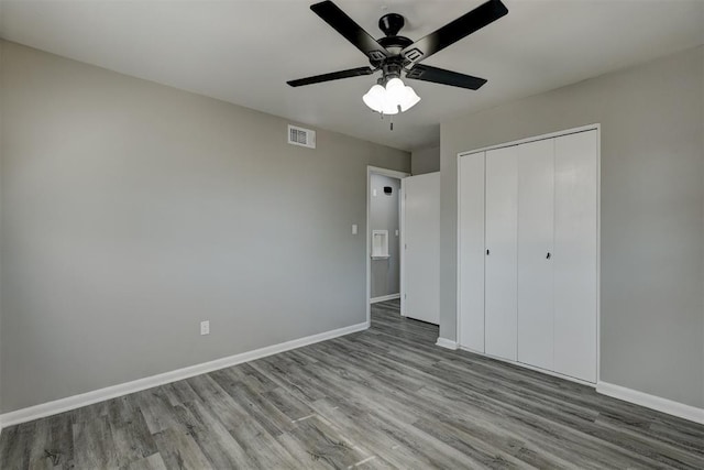 unfurnished bedroom featuring ceiling fan, a closet, and light wood-type flooring