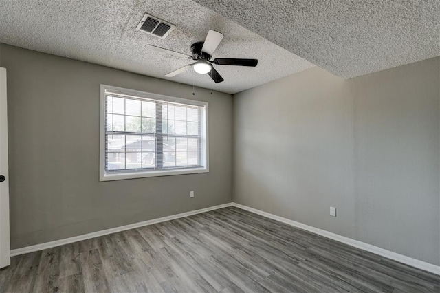 empty room with ceiling fan, a textured ceiling, and hardwood / wood-style flooring